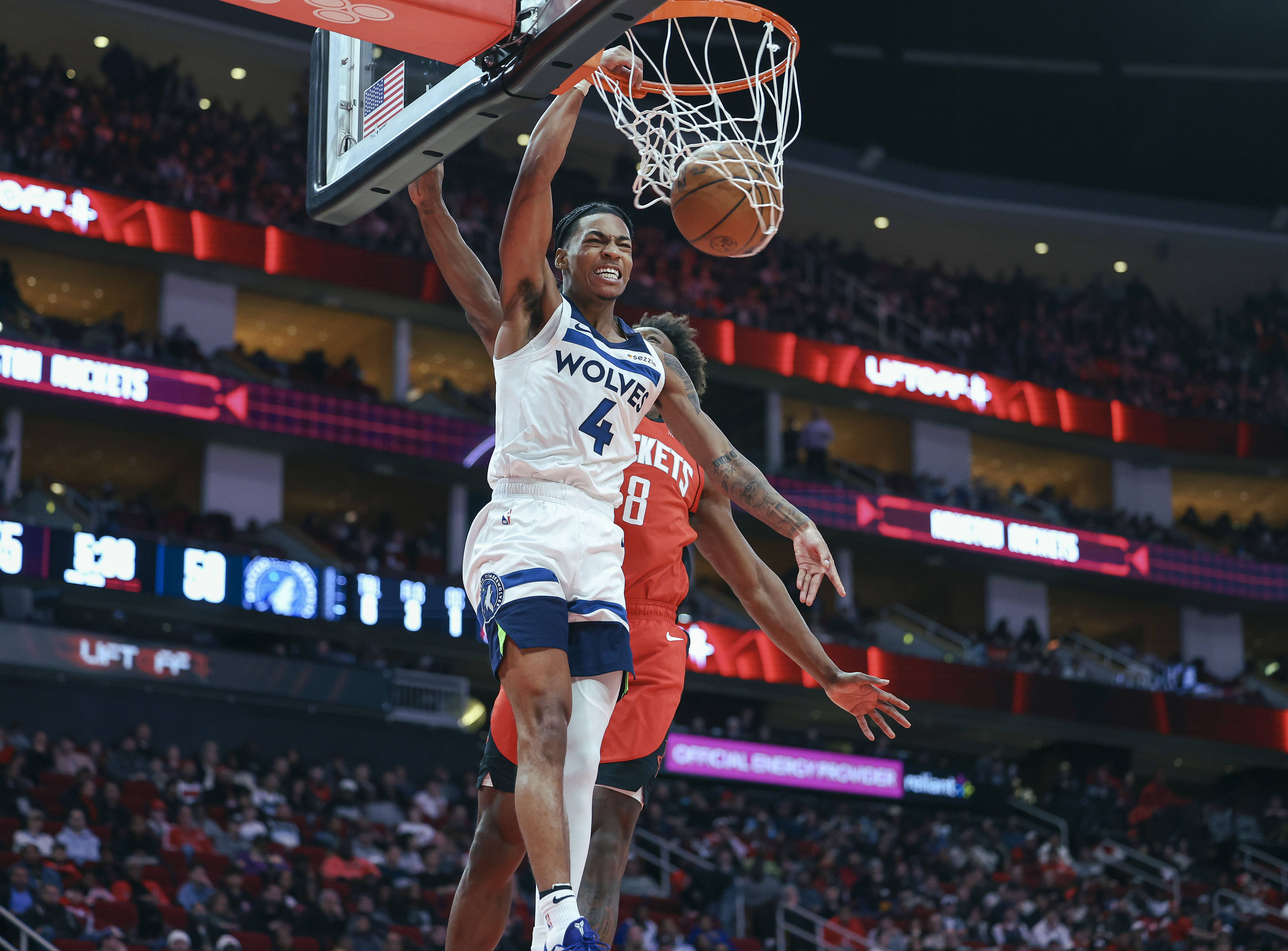 Feb 21, 2025; Houston, Texas, USA; Minnesota Timberwolves guard Rob Dillingham (4) dunks the ball as Houston Rockets forward Jae'Sean Tate (8) defends during the third quarter at Toyota Center. Mandatory Credit: Troy Taormina-Imagn Images - Source: Imagn